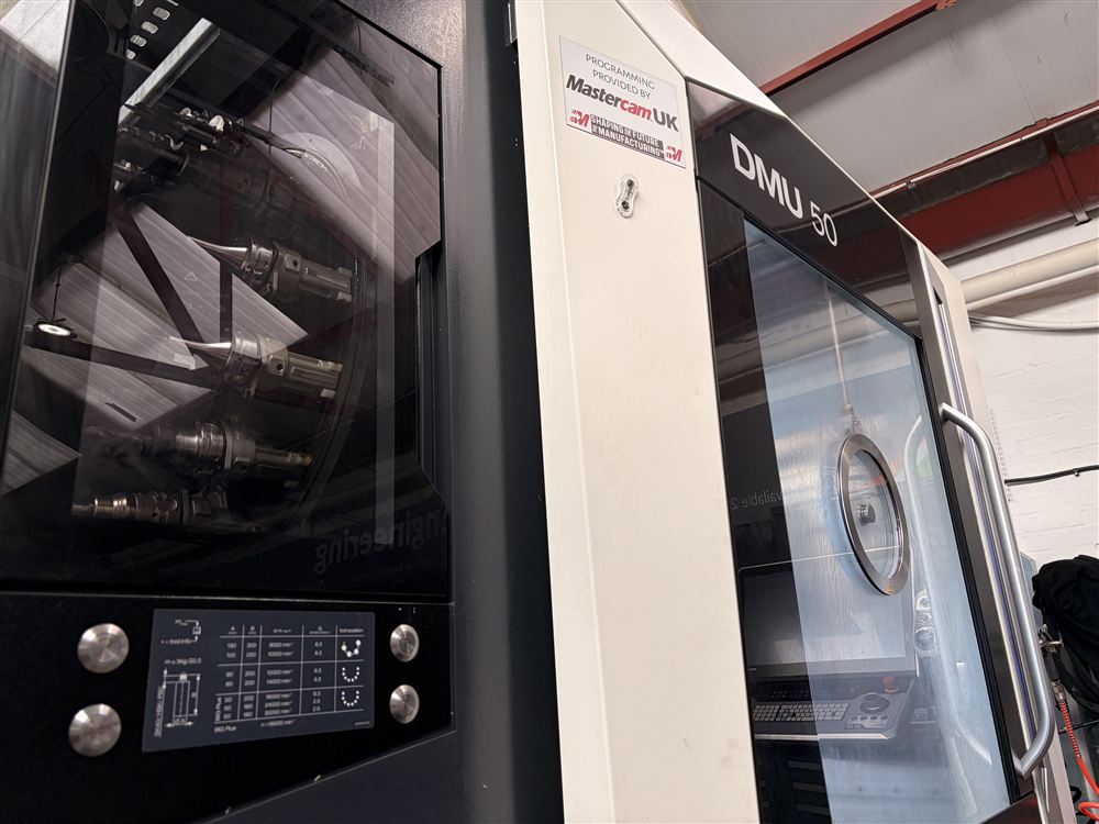 The DMG MORI DMU 50, with its tool magazine visible behind glass.