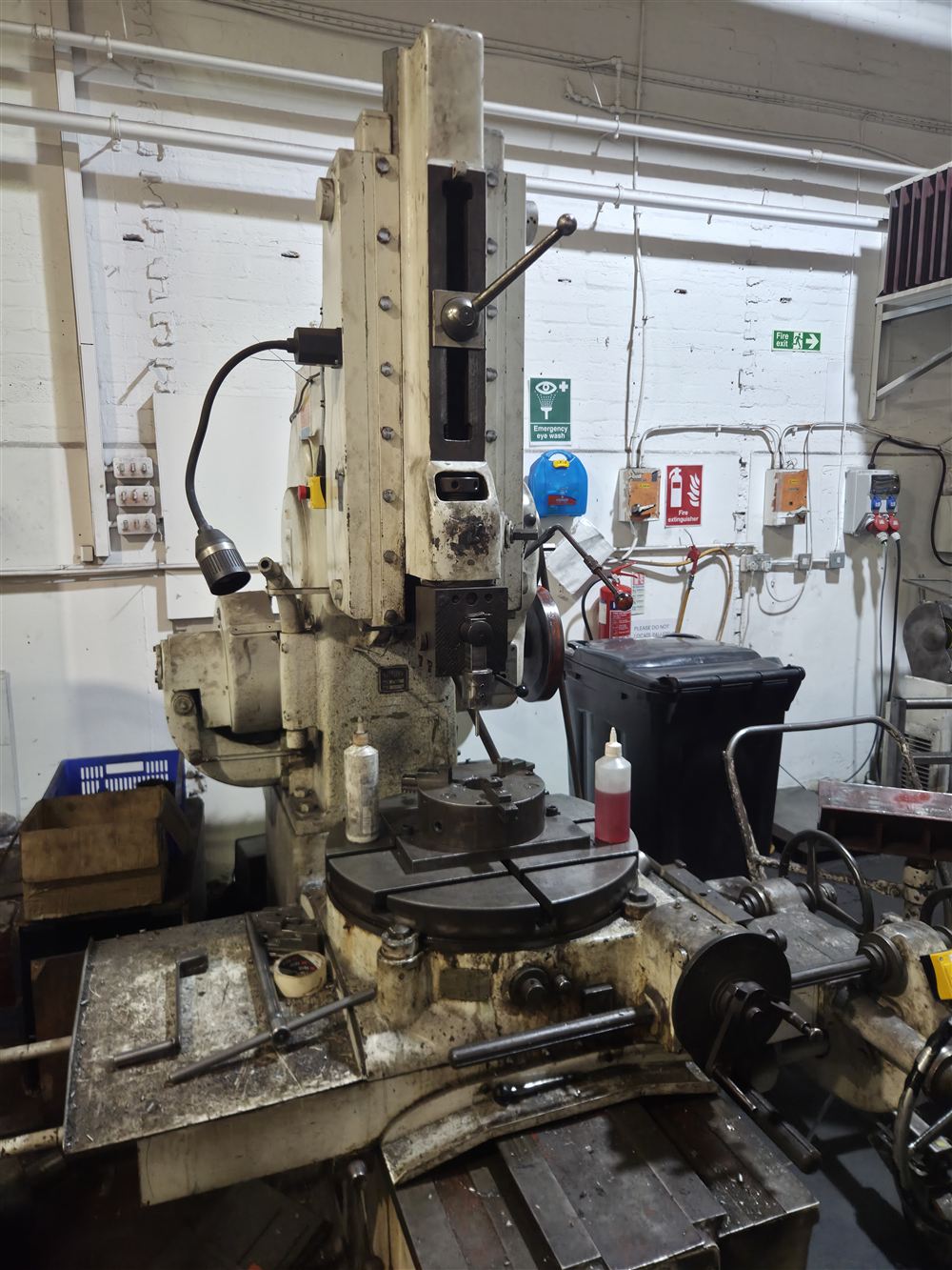 A slotting machine, its ram standing above a rotary table.